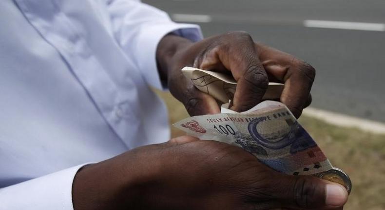 A man   counts South African rand notes in a file photo. REUTERS/Michael Buholzer