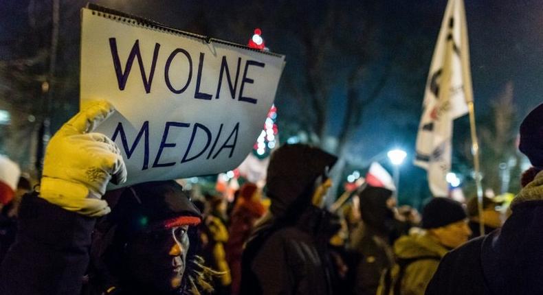 A protester holds a sign reading Free media as people gather for an anti-government demonstration by opposition supporters and Committee for the Defence of Democracy movement (KOD) outside the Polish parliament on December 16, 2016