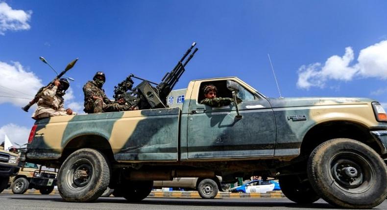 A Yemeni soldier loyal to the Shiite Huthi rebels mans a turret in the back of a pickup truck as others ride during a military parade in the capital Sanaa on October 16, 2018 to show support against the Saudi-led intervention in the country