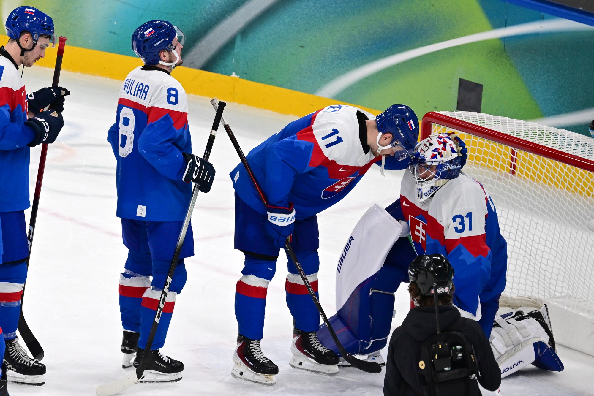 Slovenskí hokejisti Oliver Okuliar (8), Miloš Kelemen (11) a brankár Samuel Hlavaj. 