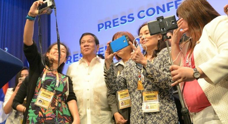 Philippines' President Rodrigo Duterte (2nd L) poses for selfie with journalists at the end of Association of Souteast Asian Nations (ASEAN) leaders' summit in Manila