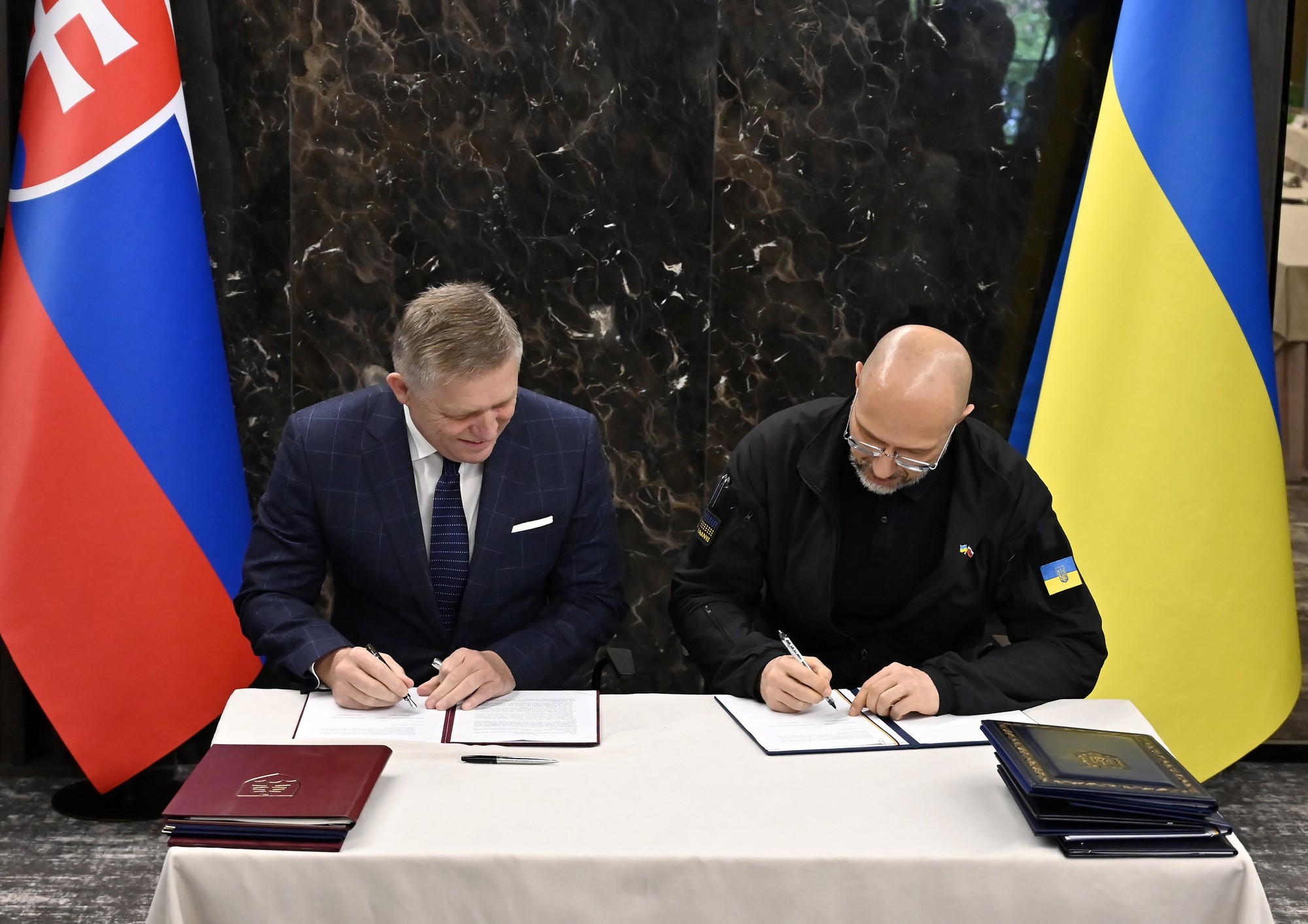Robert Fico a predseda vlády Ukrajiny Denys Šmyhaľ podpisujú deklaráciu vlád po skončení spoločného rokovania slovenskej a ukrajinskej vlády pri ukrajinskom meste Užhorod.