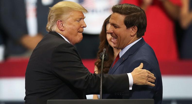 Then-President Donald Trump greets then-Florida Republican gubernatorial candidate Ron DeSantis during a campaign rally at the Hertz Arena on October 31, 2018 in Estero, Florida.