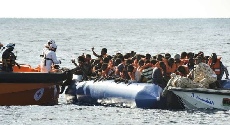 Migrants and refugees sit on a rubber boat during a rescue operation of the Topaz Responder, a rescue ship run by Maltese NGO Moas and the Italian Red Cross with the help of the Libyan coastguards, on November 4, 2016 off th Libyan coast