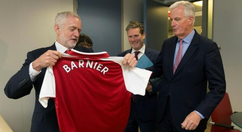 British Labour Party leader Jeremy Corbyn (L) presents EU Brexit negotiator Michel Barnier with an Arsenal football jersey at talks in Brussels