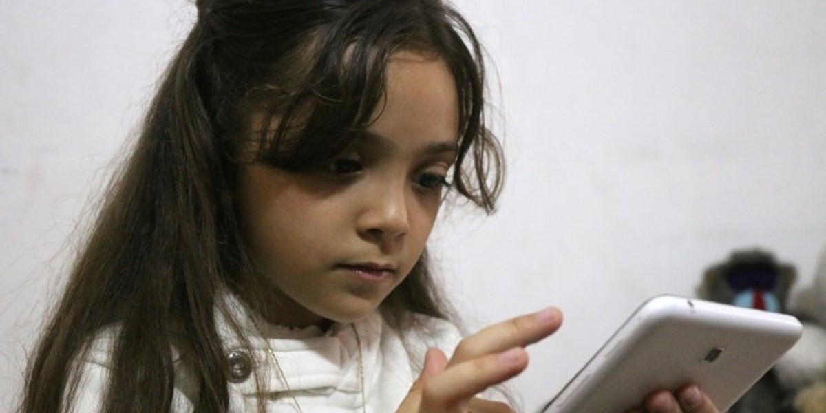 Syrian Bana al-Abed checks her Twitter account in her home in east Aleppo on October 12, 2016.