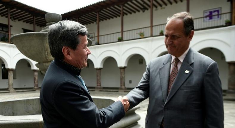 The representative of Colombian guerrilla group ELN, Pablo Beltran (L), and representative of the Colombian government Juan Camilo Restrepo shake hands at the Palacio Arzobispal in Quito where they arrived to hold a meeting on March 3, 2017