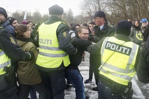 Police officers attempt to calm down people during a protest at the Danish-German border in Krusaa