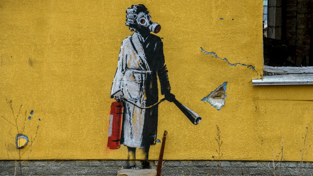 Graffiti Banksy'ego na elewacji zniszczonego budynku w Hostomelu