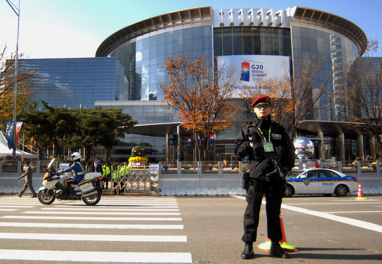 Południowo koreański policjant stoi przed budynkiem COEX, gdzie odbywa się szczyt G20. Fot: Seokyong Lee/Bloomberg