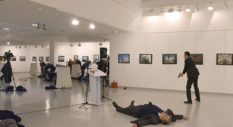 This picture taken on December 19, 2016 shows Andrei Karlov, the Russian ambassador to Ankara, lying on the floor after being shot by a gunman (R) during a public event in Ankara