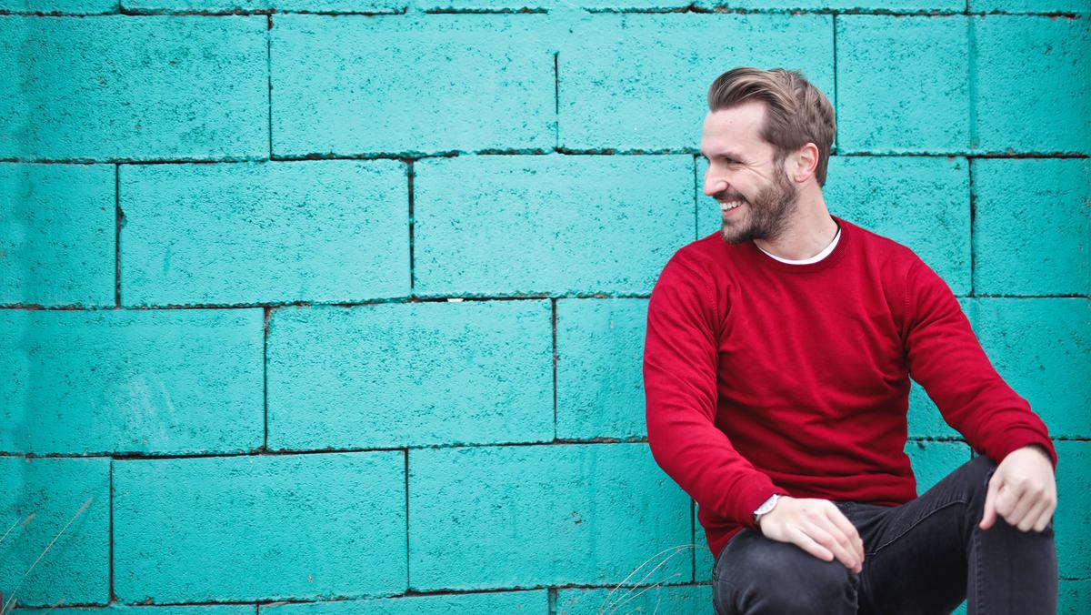 man-wearing-red-sweatshirt-and-black-pants-leaning-on-the-845434