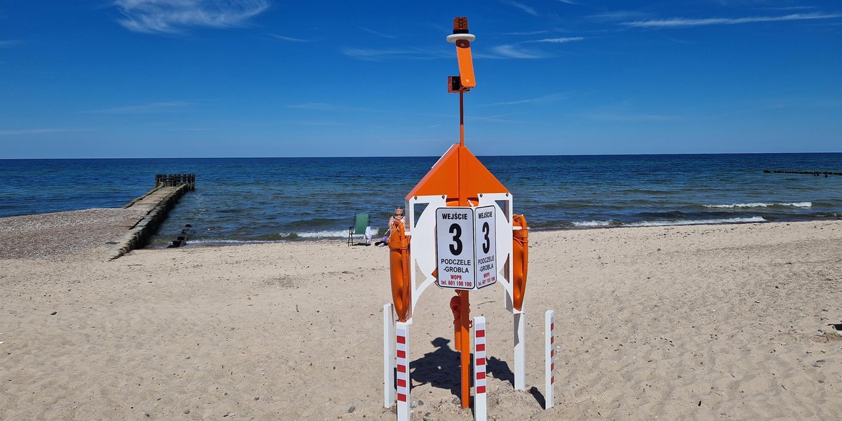 Naga kobieta klęczała w morzu na plaży w Kołobrzegu.