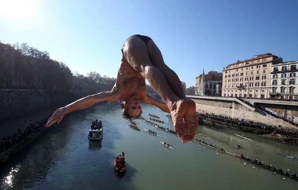 Marco Fois of Italy dives into the Tiber River from the Cavour bridge in Rome