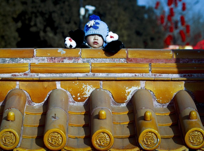 Maluch przygląda się obchodom rozpoczęcia Roku Smoka