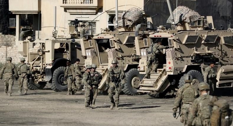 US soldiers are seen next to their armoured vehicles near an Iraqi army base on the outskirts of Mosul, on November 23, 2016 Forces battling the Islamic State group in northern Iraq cut off the jihadists' last supply line from Mosul to Syria, trapping them in the city for a bloody last stand.