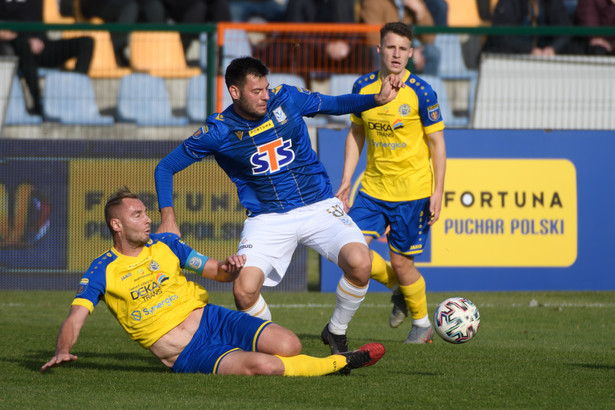 Piłkarz Unii Skierniewice Konrad Kowalczyk (L) i Roko Baturina (C) z Lecha Poznań podczas meczu 1/16 finału Pucharu Polski