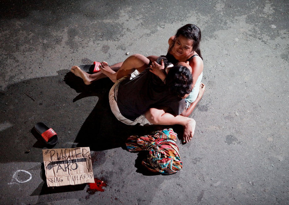 Jennelyn Olaires, 26, cradles the body of her partner, who was killed on a street by a vigilante group, according to police, in a spate of drug related killings in Pasay city, Metro Manila, July 23, 2016. A sign near the body reads "Pusher Ako," which translates to, "I am a drug pusher."