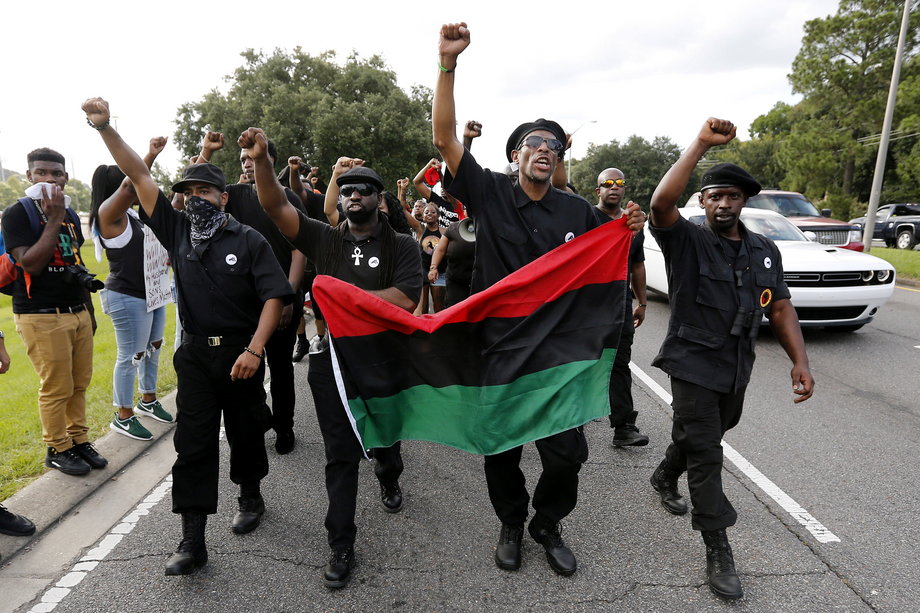 Demonstrators, wearing the insignia of the New Black Panthers Party, protest the shooting death of Alton Sterling near the headquarters of the Baton Rouge Police Department.
