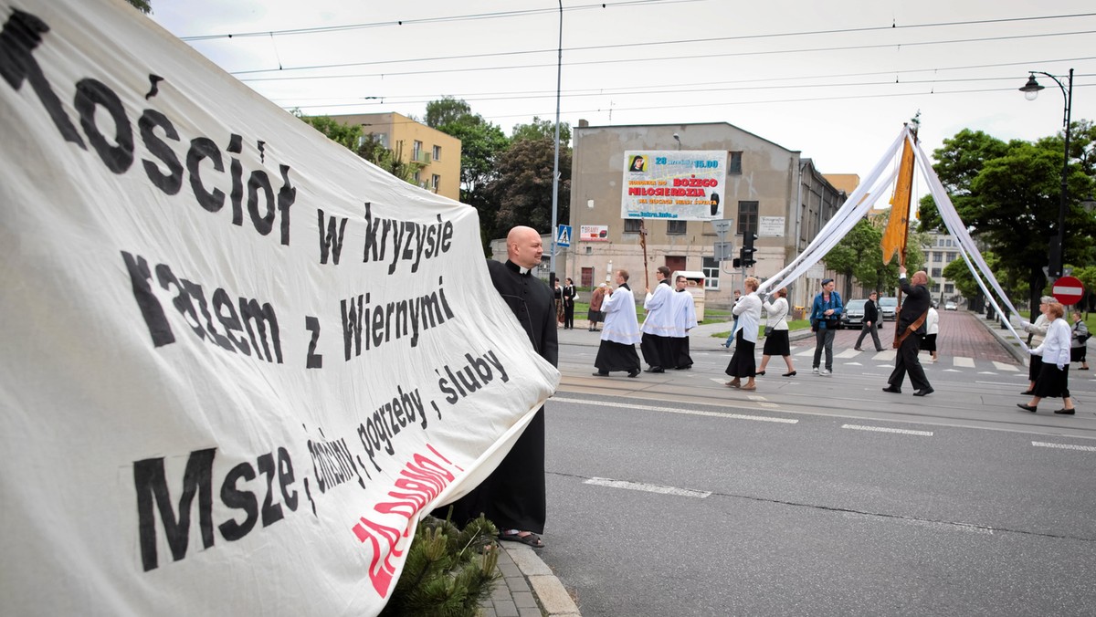 Przebrany za księdza łódzki artysta, który przed dwoma laty dołączył do procesji Bożego Ciała w przebraniu motyla, w tym roku - podczas uroczystości - rozwinął transparent z napisem "Kościół w kryzysie razem z Wiernymi, Msze, chrzciny, pogrzeby, śluby za darmo".