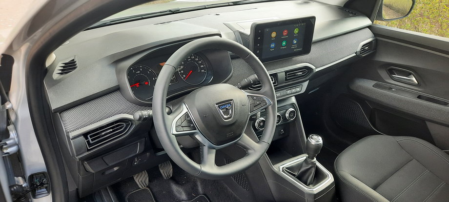 Dacia Jogger ma funkcjonalny, choć prosty kokpit. W testowanej wersji nie zabrakło bogatego wyposażenia. Na 8-calowym ekranie pojawia się obraz z kamery cofania, mamy też nawigację i  możliwość korzystania z telefonu.