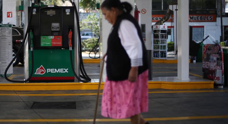 A woman walks next to fuel pumps at Pemex gas station in Mexico City, Mexico, on December 28.