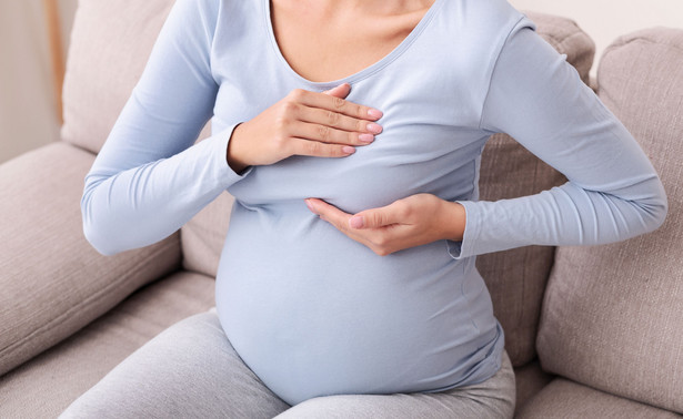 Kobieta w ciąży bada piersi