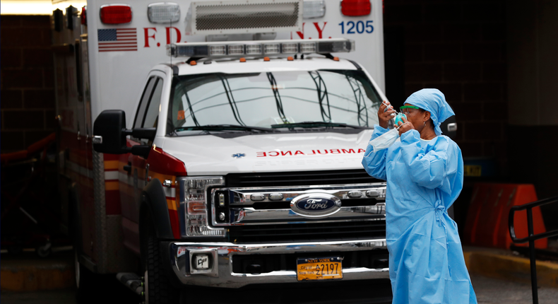 An emergency room nurse dons her face protectors after taking a break in a driveway for ambulances and emergency medical services vehicles outside Brooklyn Hospital Center's emergency room, Sunday, April 5, 2020, in New York, during the coronavirus crisis. (AP Photo/Kathy Willens)