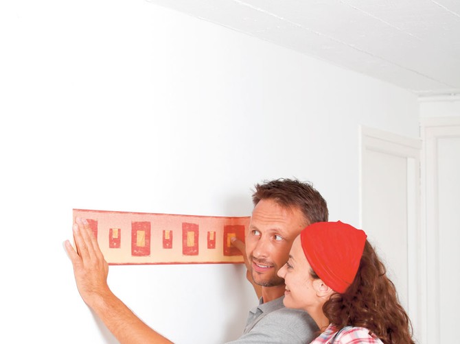 12621_stock-photo-couple-standing-in-their-home-with-paperwall-rolls-shutterstock_62354437