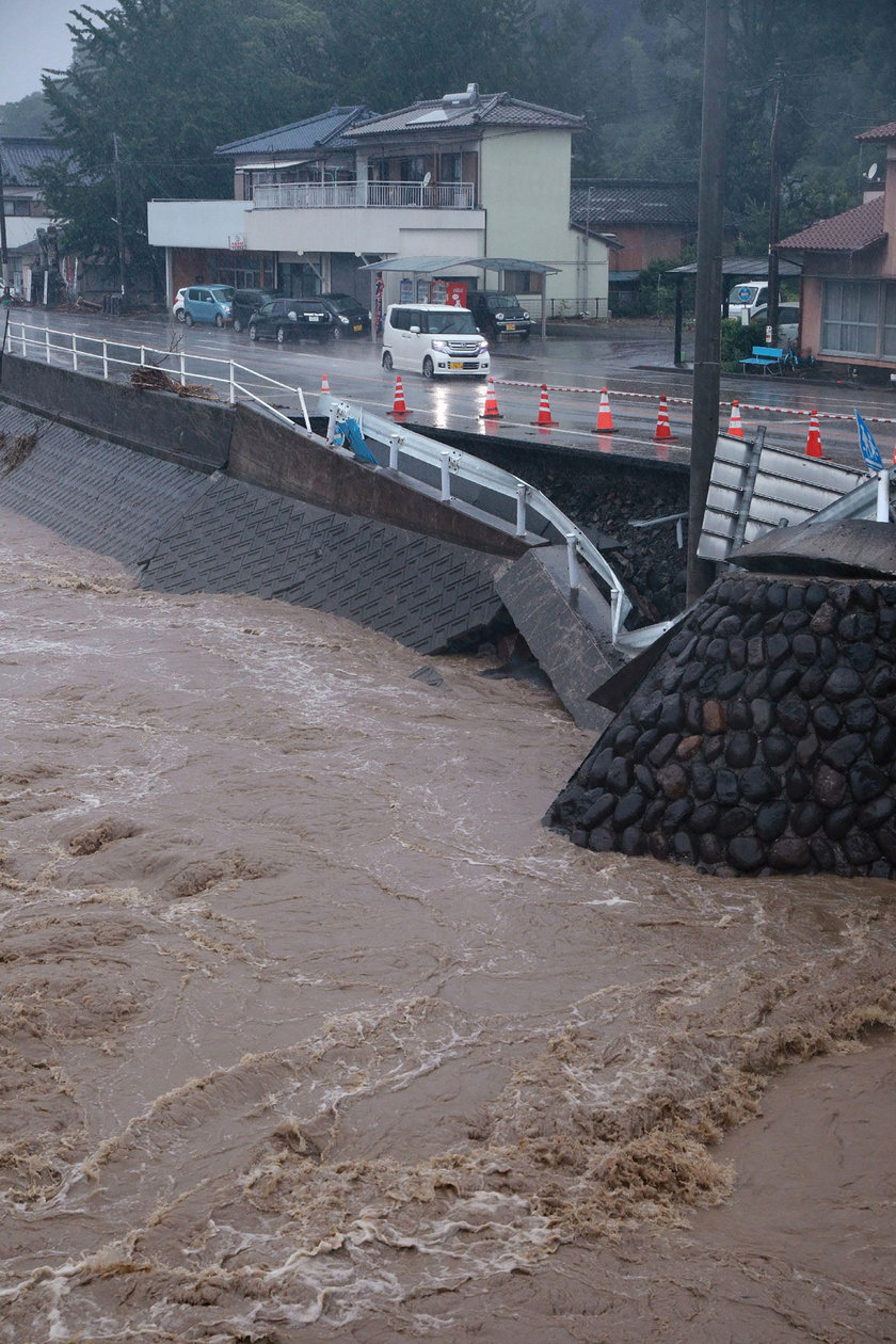 A car is pictured after it was drifted by torrential rain in Hitoyoshi