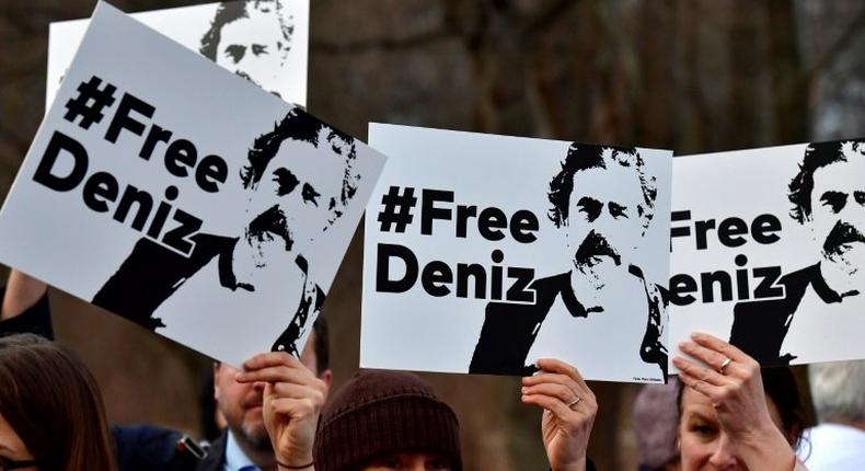 People hold placards with hashtag #FREEDENIZ to protest the detantion of German journalist Deniz Yucel in front of Turkish embassy in Berlin on February 28, 2017