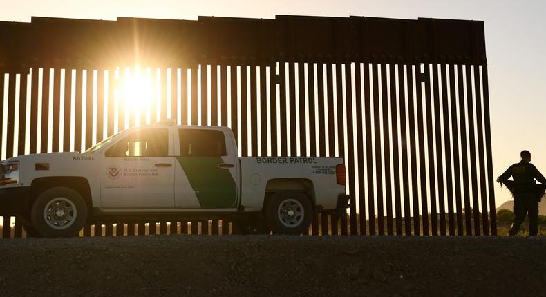 A Border Patrol agent walks between a gap along the border wall between the US and Mexico in Yuma, Arizona on June 1, 2022.PATRICK T. FALLON/AFP via Getty Images