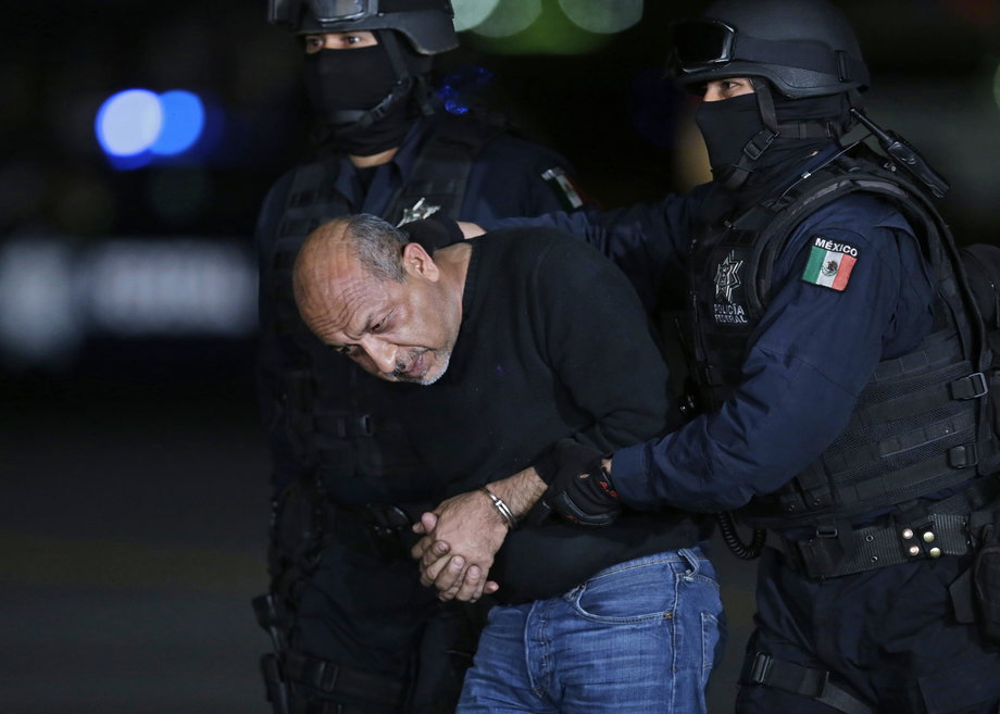 Servando "La Tuta" Gomez is escorted by police officers during a media conference about his arrest in Mexico City, February 27, 2015.