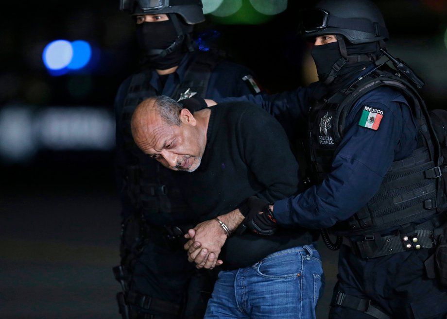 Servando "La Tuta" Gomez is escorted by police officers during a media conference about his arrest in Mexico City, February 27, 2015.