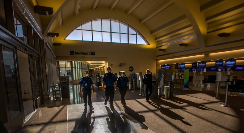 TSA agents walking trough a terminal.
