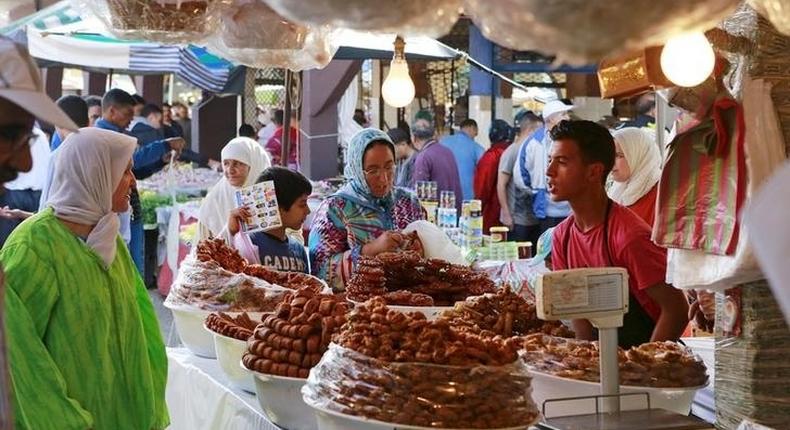 A vendor sells traditional cakes of fried honey and flour pastries to customers during the first day of Ramadan in the medina of the Moroccan city of Oujda June 18, 2015. REUTERS/Youssef Boudlal