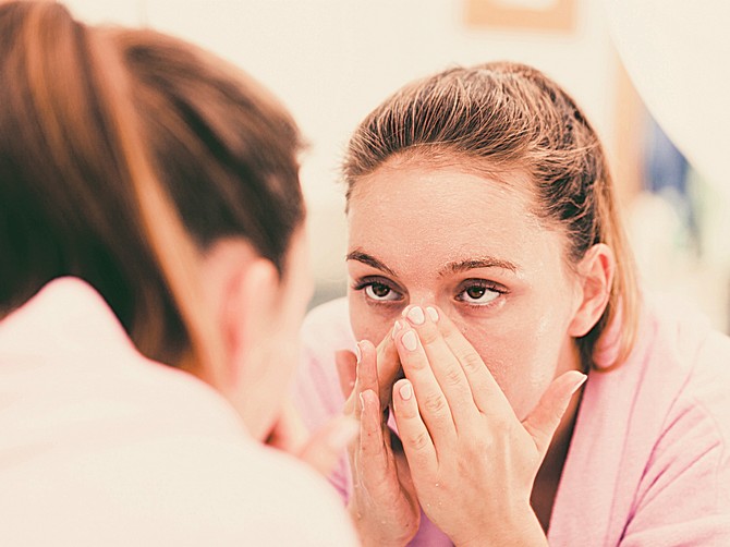 128674_stockphotowomancleaningpeelingherfaceinbathroommakingfacialmassagewithscrubgirltakingcareof420235780