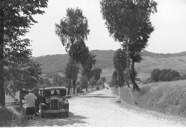 Droga Sanok-Tyrawa Wołoska. Na poboczu widoczni ludzie stojący przy samochodzie osobowym, lata 30. XX wieku