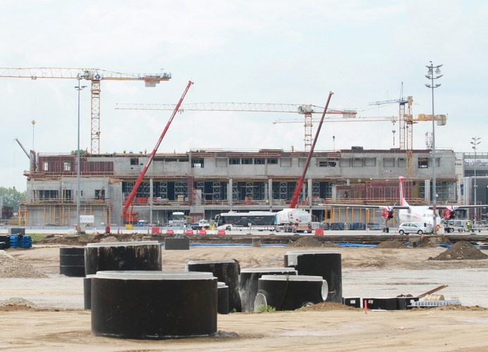 Na poziomie 0, w nowej - wschodniej części terminalu, dla pasażerów przylatujących do Krakowa zabudowana zostanie nowa sala odbioru bagażu rejestrowanego.<br><br> <b>Na zdjęciu: </b>Na pierwszym planie - budowa miejsc pod nowe miejsca postojowe, w tle budowa nowego terminalu na lotnisku Kraków-Balice.

<br><br> fot.(dw) PAP/Stanisław Rozpędzik