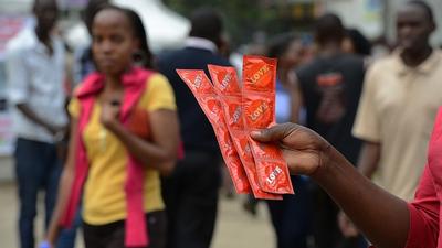 An Aids Healthcare Foundation-Kenya worker distributes condoms in the streets of Nairobi on February 14, 2014 to promote safe sex practices during the Valentine week and to mark the International Condom Day. A non-governmental organisation is planning to test at least 5,000 people for HIV-Aids and distribute 200,000 condoms over the valentine weekend. AFP PHOTO/SIMON MAINA (Photo credit should read SIMON MAINA/AFP via Getty Images)