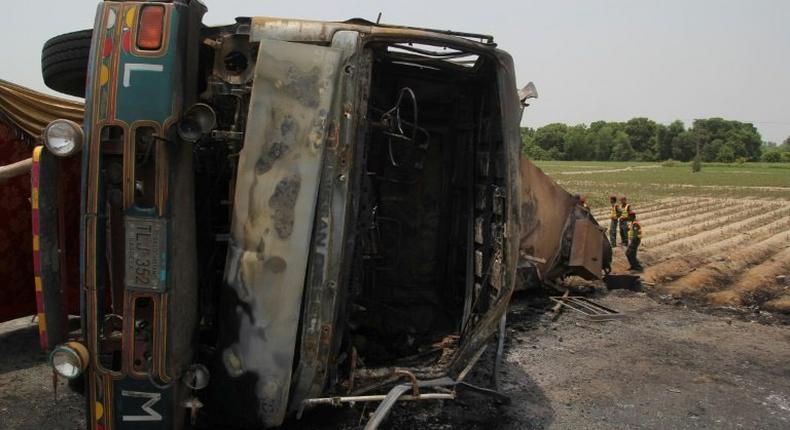 Pakistani rescue workers gather beside an oil tanker which caught fire following an accident on a highway near the town of Ahmedpur East