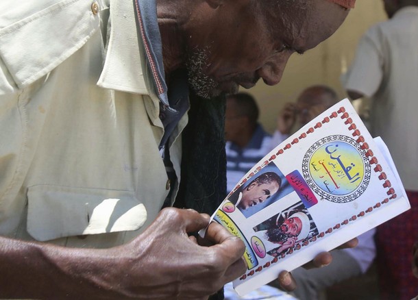 A man reads a book at a bookstall in southern Mogadishu October 10, 2013. Street lamps now brighten 