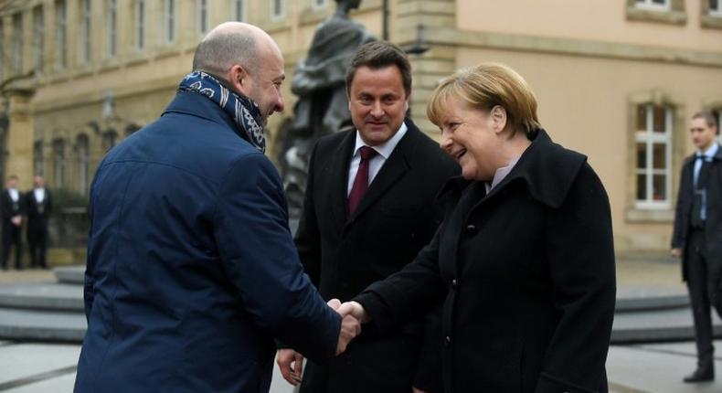 Luxembourg's Prime minister Xavier Bettel (C) and Deputy Prime Minister Etienne Schneider welcome German Chancellor Angela Merkel (R) during a visit in Luxembourg on January 12, 2017