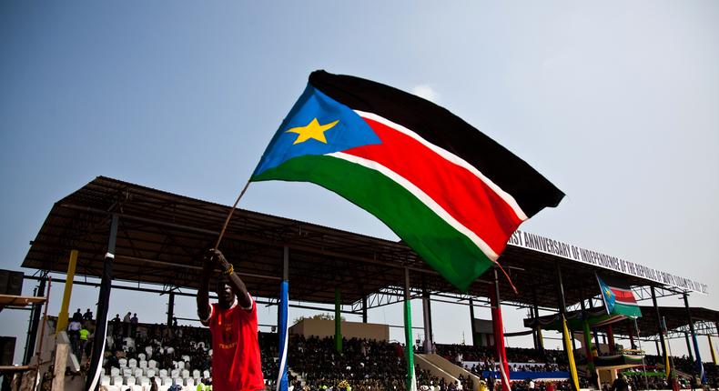 A man waves the national flag of South Sudan during celebrations to mark the country's first anniversary of its independence in Juba, July 9, 2012.