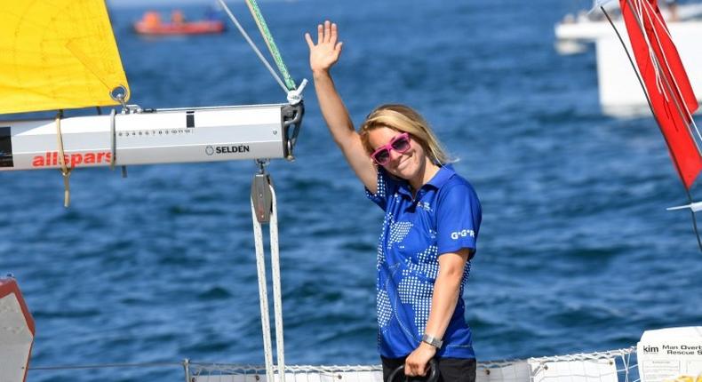 British skipper Susie Goodall waves from the helm of her boat DHL Starlight on July 1, 2018, at the start of her solo around-the-world Golden Globe Race in which sailors compete without high technology aides such as GPS or computers
