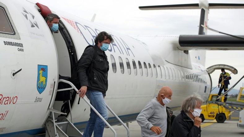 Passengers wearing masks get off a plane at Zagreb International Airport Croatia, on May 11, 2020