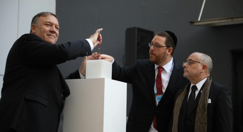 US Secretary of State Mike Pompeo lights a candle next to Argentine Foreign Minister Jorge Faurie and the president of the Asociacion Mutual Israelita Argentina (AMIA) Ariel Eichbaum to pay homage to the victims of a bombing at the center which left 85 people dead