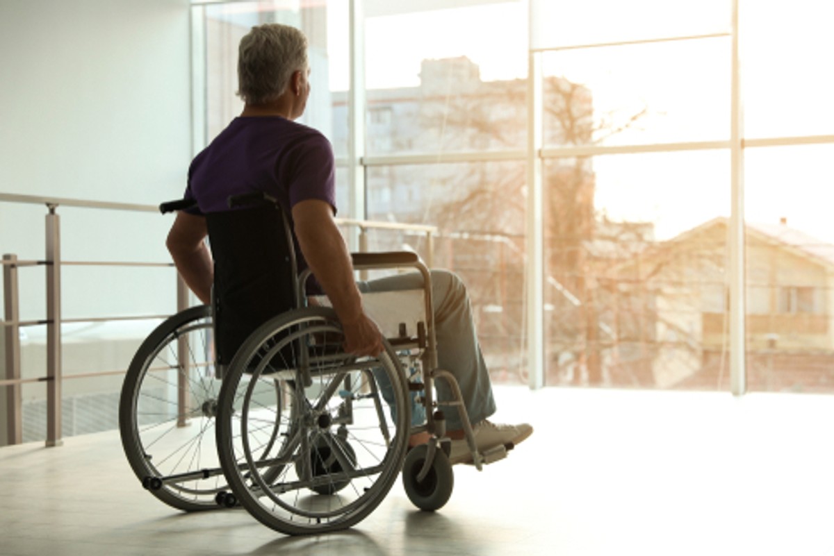 Senior,Man,Sitting,In,Wheelchair,Near,Window,At,Home