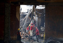Workers remove debris in a gutted slipper factory in Valenzuela