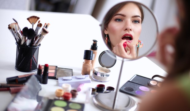stock-photo-young-beautiful-woman-making-make-up-near-mirror-sitting-at-the-desk-603418379